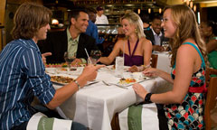 A mature couple holds hands and shares a happy moment over glasses of wine at the California Grill at Disney's Contemporary Resort.
