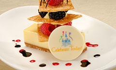 Slice of pie layered with wafers, assorted berries and a candy medallion that exclaims, Celebrate Today!