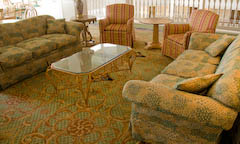 Finely upholstered living room with glass coffee table and area rug
